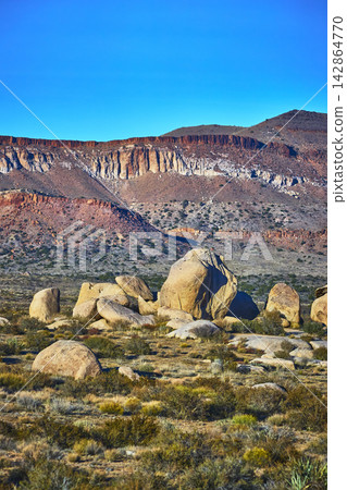 Desert Boulders and Rugged Cliffs under Blue Sky in Mojave California Desert Boulders and Rugged Cliffs under Blue Sky in Mojave California 142864770