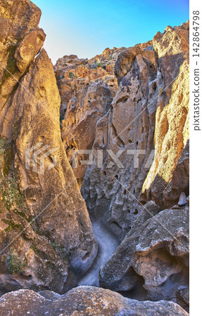 Sandstone Rock Formations and Winding Desert Trail in Sunlit Mojave Canyon Sandstone Rock Formations and Winding Desert Trail in Sunlit Mojave Canyon 142864798