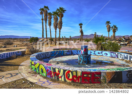 Abandoned Graffiti Covered Fountain Desert Palm Trees and Ruins at Lake Dolores Water Park Abandoned Graffiti Covered Fountain Desert Palm Trees and Ruins at Lake Dolores Water Park 142864802