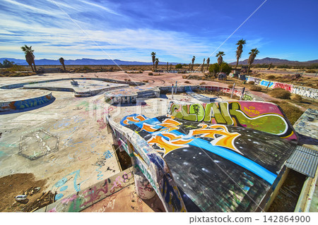 Abandoned Water Park Graffiti Art and Palm Trees in California Desert Landscape Abandoned Water Park Graffiti Art and Palm Trees in California Desert Landscape 142864900