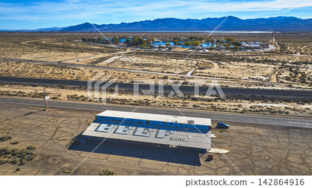 Aerial Abandoned Gas Station Desert Road and Distant Buildings in Yermo California Aerial Abandoned Gas Station Desert Road and Distant Buildings in Yermo California 142864916