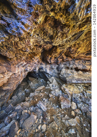 Lava Tube Cave Interior Rugged Volcanic Rock Formations and Sunlit Entrance Lava Tube Cave Interior Rugged Volcanic Rock Formations and Sunlit Entrance 142864919