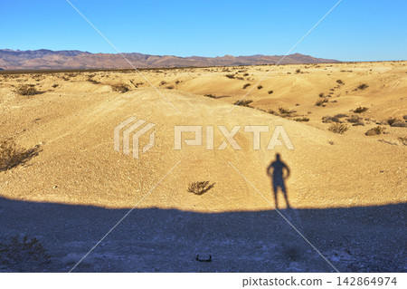 Golden Hour Shadow Self Portrait in Desert Landscape with Distant Mountains Golden Hour Shadow Self Portrait in Desert Landscape with Distant Mountains 142864974