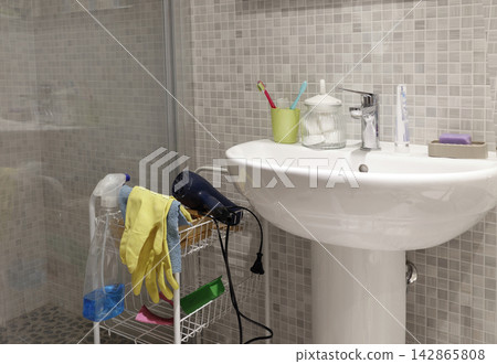 White ceramic pedestal sink with chrome faucet and personal hygiene accessories. White ceramic pedestal sink with chrome faucet and personal hygiene accessories. 142865808