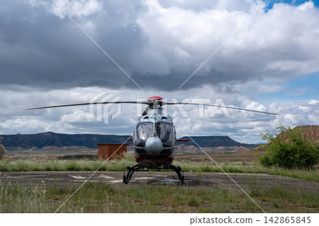 Military helicopter front view on helipad with dramatic cloudy sky Military helicopter front view on helipad with dramatic cloudy sky 142865845