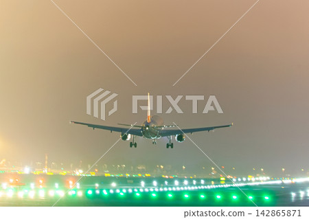 Airplane landing on runway at night Airplane landing on runway at night 142865871
