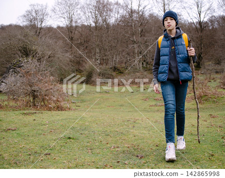 Hiking young person in nature with a stick 142865998