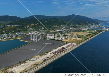 Aerial photograph showing solar panels and port facilities along the coast of Awaji City, Hyogo Prefecture. 142866188