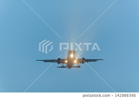Airplane approaching with landing lights Airplane approaching with landing lights 142866398