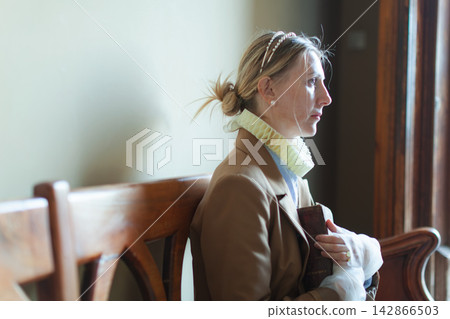 Woman in costume holding book Woman in costume holding book 142866503