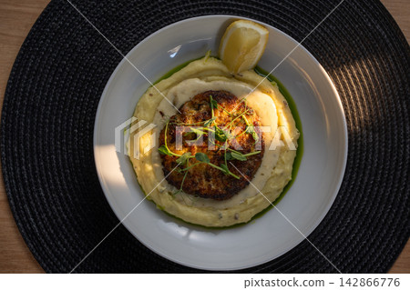 Meat kotlet on potato puree top view with lemon on wooden table Meat kotlet on potato puree top view with lemon on wooden table 142866776