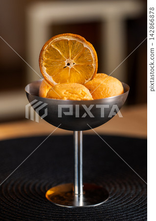 Orange sorbet in dark coupe side view lighter background Orange sorbet in dark coupe side view lighter background 142866878