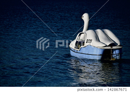 Swan boats leisurely gliding across Lake Toya in Hokkaido. Swan boats leisurely gliding across Lake Toya in Hokkaido. 142867671