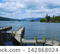 Mountain scenery overlooking Lake Windermere and a wooden pier in the Lake District. 142868024