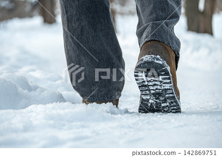 Winter boots walking on snow close up Winter boots walking on snow close up 142869751