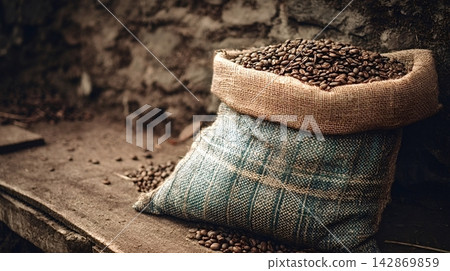 Roasted coffee beans spilling from burlap sack Roasted coffee beans spilling from burlap sack 142869859