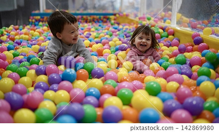 Happy children playing in colorful ball pit at indoor playground Happy children playing in colorful ball pit at indoor playground 142869980