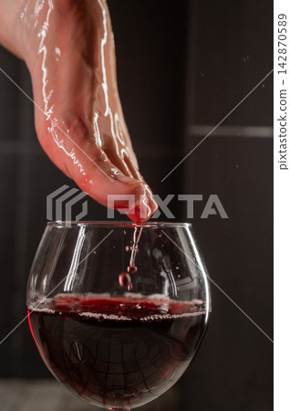 Foot fetish. A woman dips her toes in a glass of red wine. Foot fetish. A woman dips her toes in a glass of red wine. 142870589