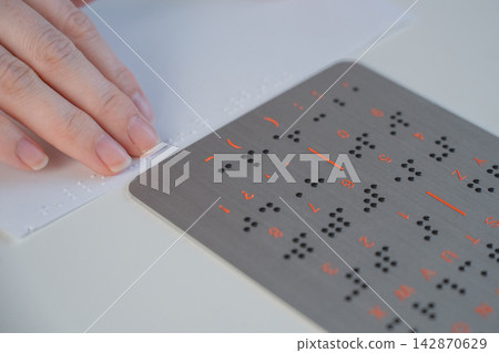 A woman learns to read Braille. A woman learns to read Braille. 142870629