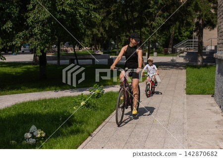 Mother and son riding a bicycle. Mother and son riding a bicycle. 142870682