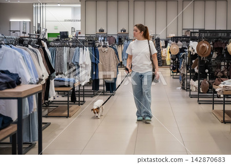 Caucasian woman in a shopping mall with a Jack Russell Terrier dog.  142870683