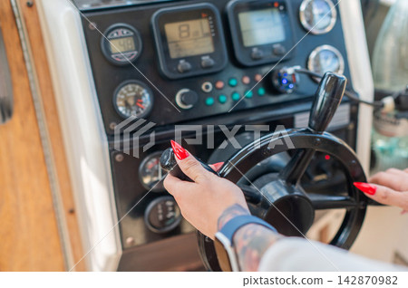 Women's hands at the helm of a yacht. Women's hands at the helm of a yacht. 142870982