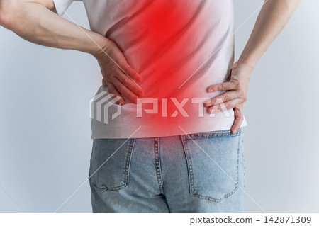 A Caucasian woman suffers from back pain. The pain is shown in the red circle. A Caucasian woman suffers from back pain. The pain is shown in the red circle. 142871309
