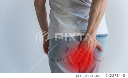 A woman suffers from hemorrhoids. Pain in the form of a red spot. 142871448