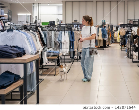 Caucasian woman in a shopping mall with a Jack Russell Terrier dog. Caucasian woman in a shopping mall with a Jack Russell Terrier dog. 142871644