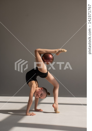 Little gymnast posing with a ball on a white background. Little gymnast posing with a ball on a white background. 142871767