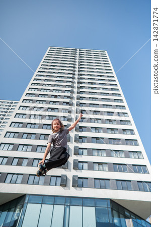A girl jumps on an outdoor trampoline. A girl jumps on an outdoor trampoline. 142871774