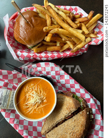 Burger and fries with a tomato soup and sandwich lunch combination Burger and fries with a tomato soup and sandwich lunch combination 142872245