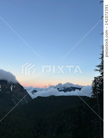 Mountain peaks above the clouds at sunset, Mount Rainier National Park Mountain peaks above the clouds at sunset, Mount Rainier National Park 142872391