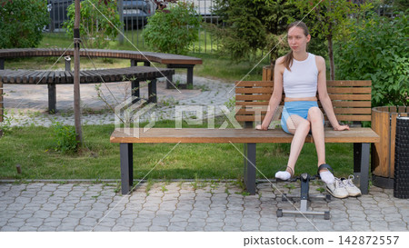 A woman uses Pedal Exercise Machine for self-rehabilitation outdoors. A woman uses Pedal Exercise Machine for self-rehabilitation outdoors. 142872557
