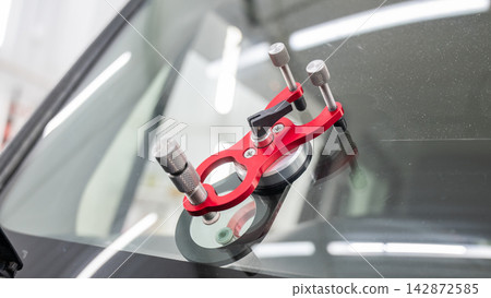 Repairing a chip on a car windshield.  142872585