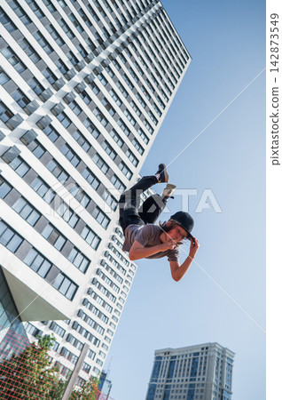 A girl jumps on a gymnastic trampoline. A girl jumps on a gymnastic trampoline. 142873549