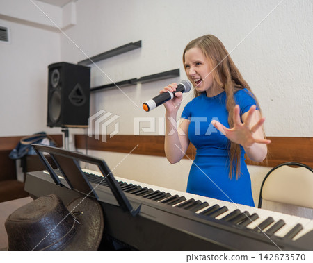 Caucasian woman singing into microphone. Caucasian woman singing into microphone. 142873570