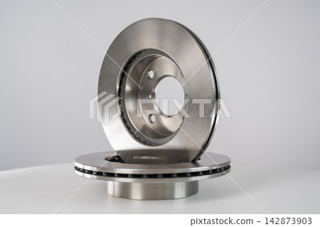 A close-up of new brake discs on a white background. A close-up of new brake discs on a white background. 142873903