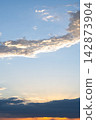 Peaceful sunset sky with soft cloud, bright sunlight, tranquil atmosphere, golden twilight horizon offering beautiful copy space 142873904