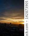 Dramatic sunset cloudscape over city skyline evokes peaceful serene mood with golden sunlight and dark twilight atmosphere 142873905