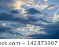 Dramatic sky view showing dark cloud formation and peaceful sunlight during scenic atmospheric sunset with dramatic weather mood 142873907
