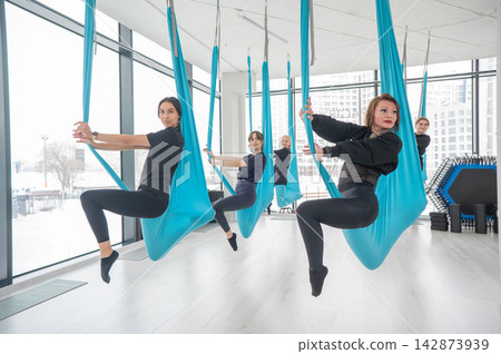 Group yoga class on hammocks. Group yoga class on hammocks. 142873939