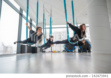 Group yoga class on hammocks. Group yoga class on hammocks. 142873941