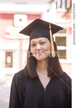 Happy young asian woman in graduation gown. Happy young asian woman in graduation gown. 142874368