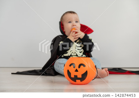 Cute caucasian boy in dracula halloween costume holding candy basket on white background. Cute caucasian boy in dracula halloween costume holding candy basket on white background. 142874453