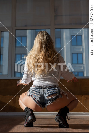 A Caucasian woman dances twerk in a dance class. A Caucasian woman dances twerk in a dance class. 142874552