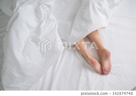Foot fetish. Bare female feet protruding from under the blanket. Foot fetish. Bare female feet protruding from under the blanket. 142874748