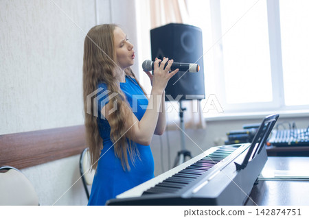 Caucasian woman singing into microphone. Caucasian woman singing into microphone. 142874751