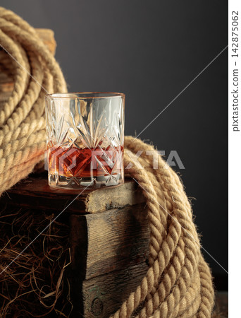 Glass of whiskey on a rough wooden crate. Glass of whiskey on a rough wooden crate. 142875062
