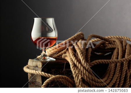 Glass of whiskey on a rough wooden crate. Glass of whiskey on a rough wooden crate. 142875083
